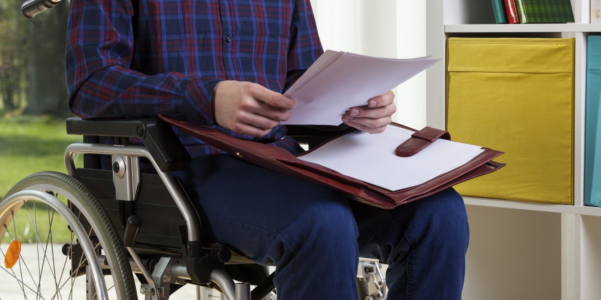 Young man on wheelchair reading documents at home