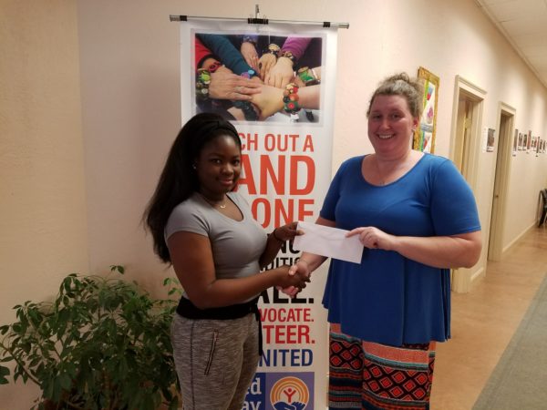 Student receiving scholarship from woman at United Way