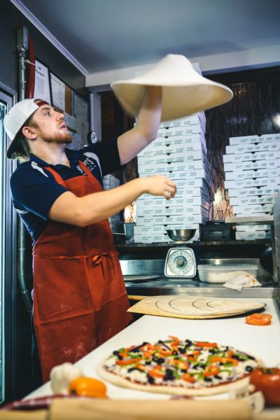 Man tossing pizza crust