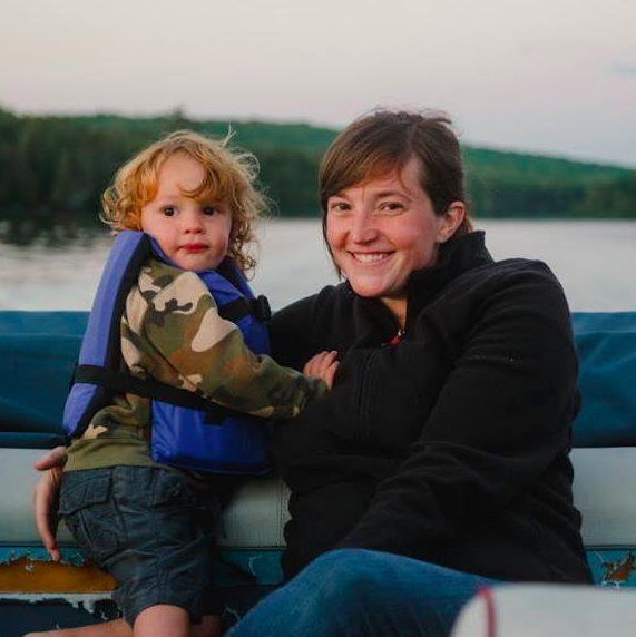 Toddler in a boat with his mother.