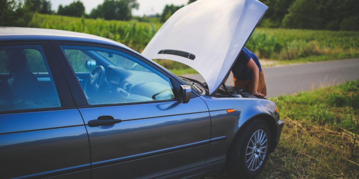 someone looking at a car with the hood up