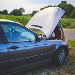 someone looking at a car with the hood up