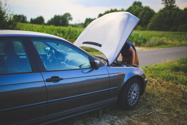 someone looking at a car with the hood up