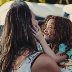 young girl with her hands on her mother's face