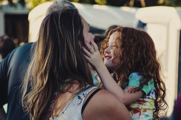 young girl with her hands on her mother's face