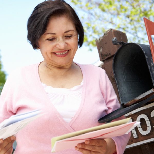 Photo of senior getting mail from her mailbox.