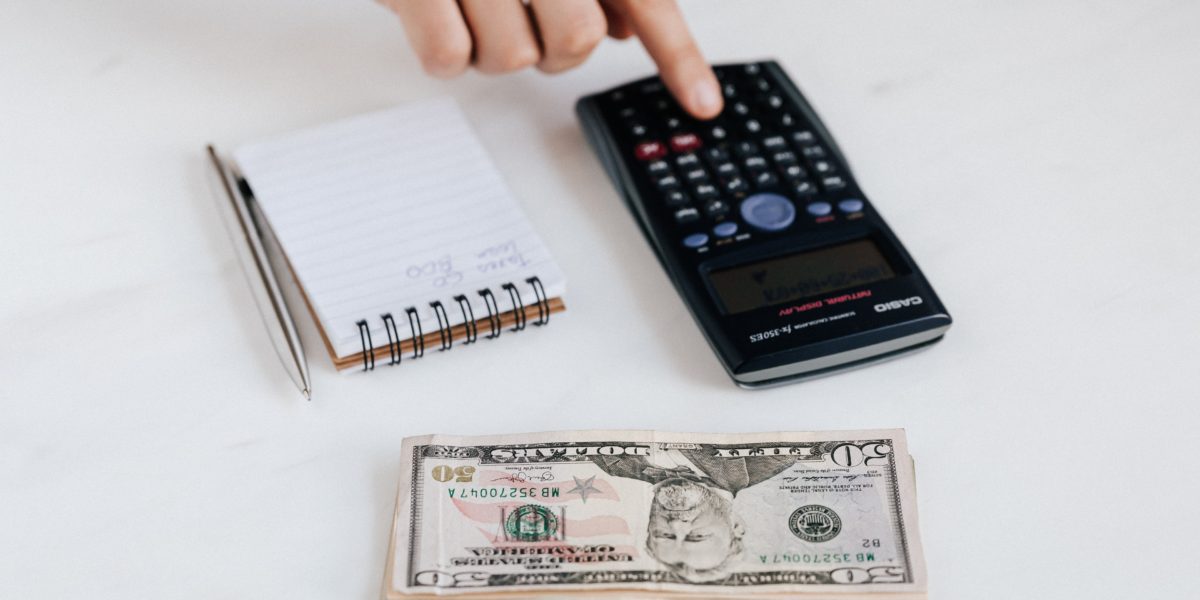 notebook, calculator, and stack of money