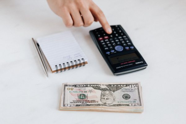notebook, calculator, and stack of money