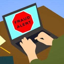 illustration of a red (stop) fraud alert sign on computer with person's hands on keyboard