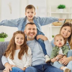 family of five siitting on their couch